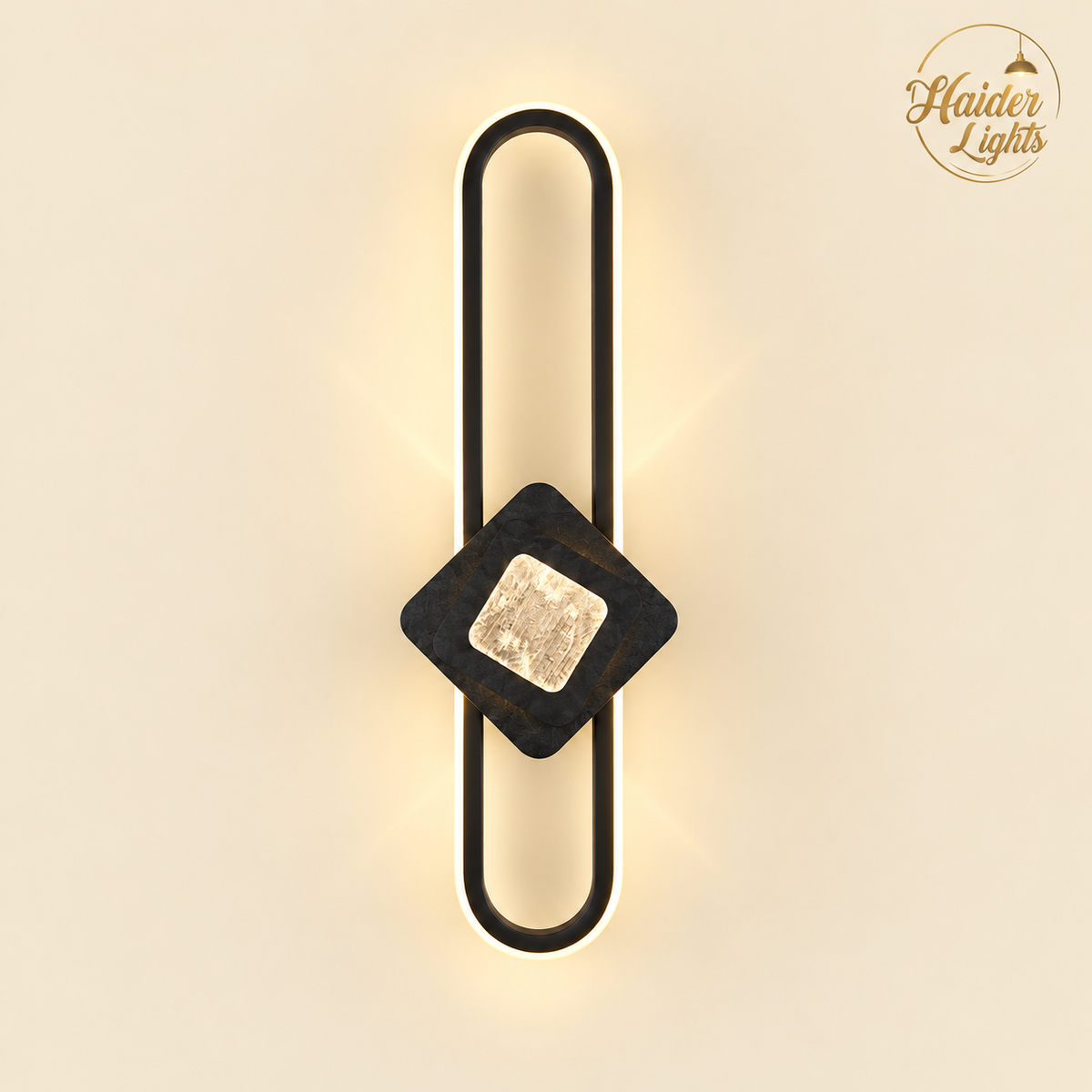A modern wall sconce light fixture with a black metal U-shaped frame, a dark wood diamond accent, and a textured gold square in the center, emitting a warm glow against a beige background. The Haider Lights logo is visible in the top right corner.